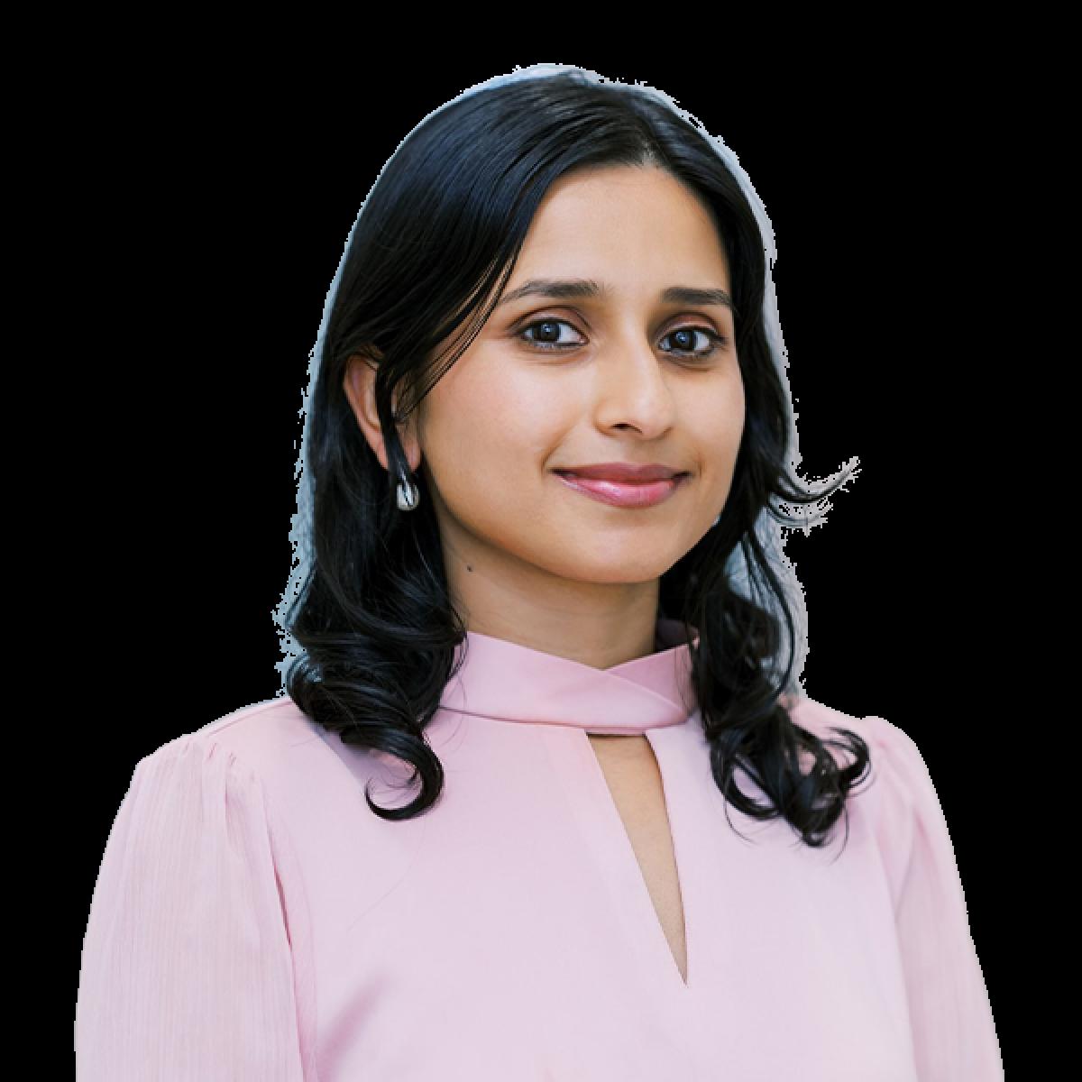 Professional female healthcare practitioner headshot in pink blouse against white background