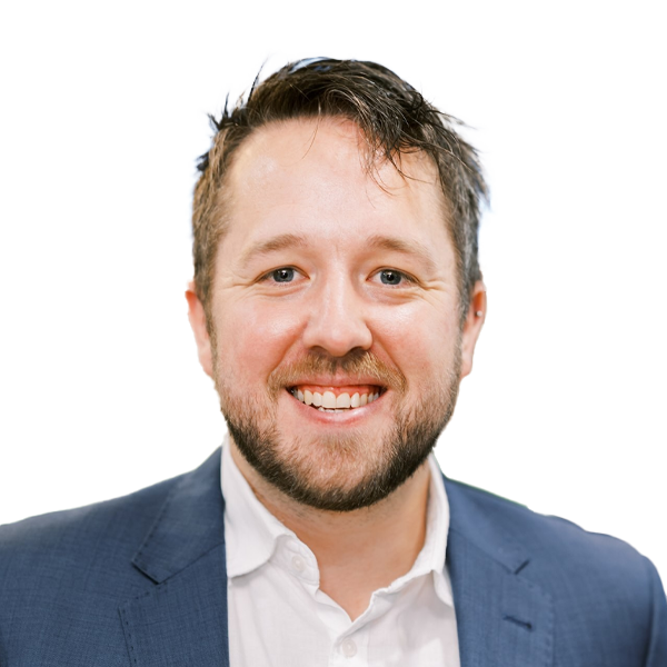 Professional headshot of smiling male doctor in navy suit jacket and white shirt against white background