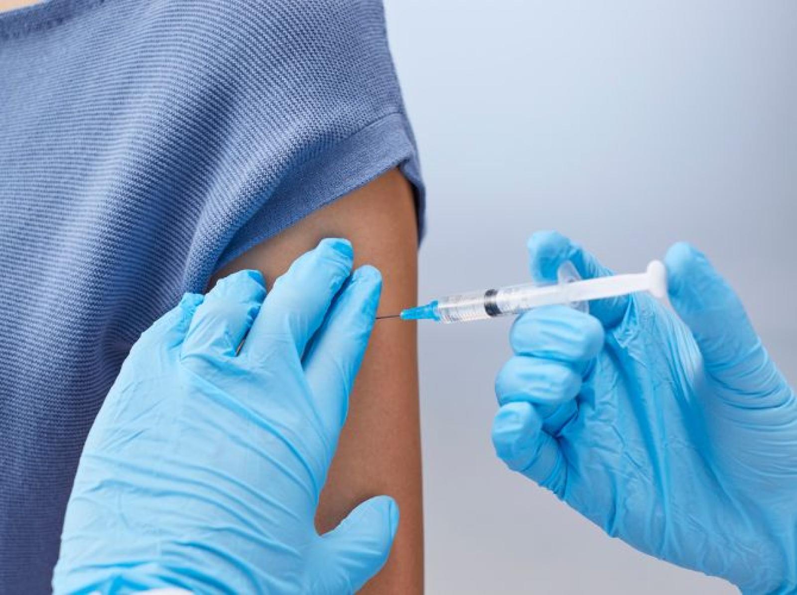 Healthcare professional administering a vaccine injection into a patient’s upper arm